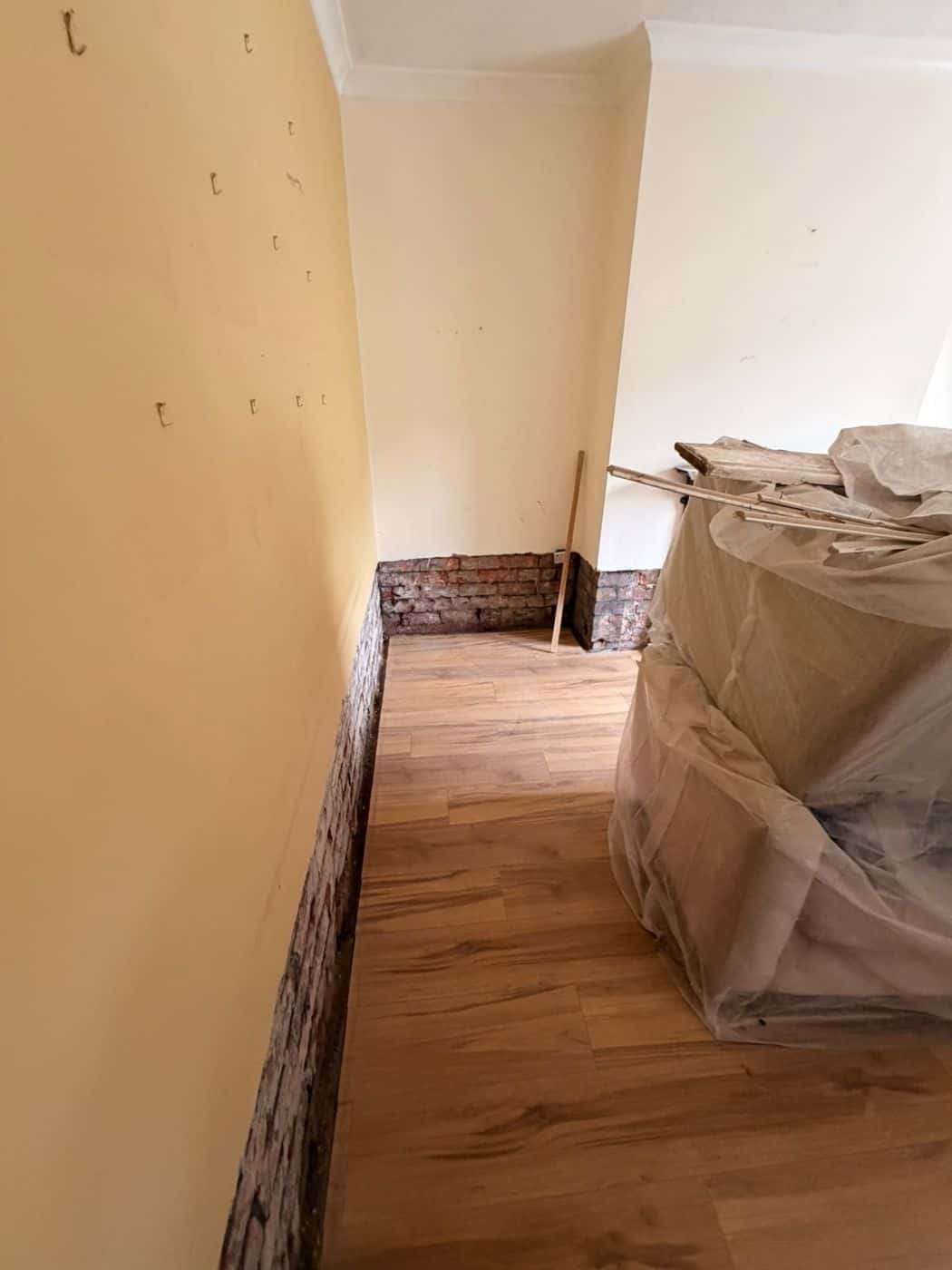Plaster stripped back to brick to expose the full extent of the damp