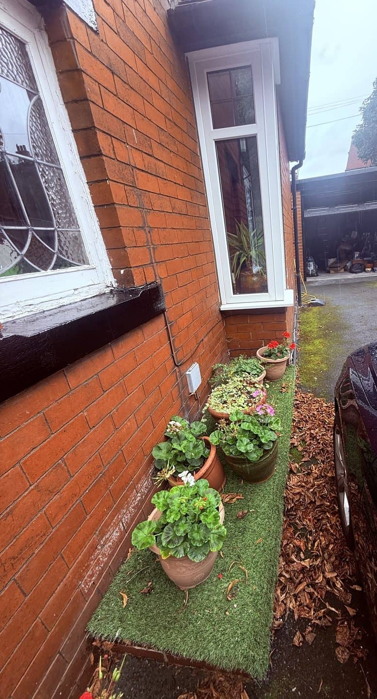 Narrow side passage alongside the property with the drain run falling away towards the road
